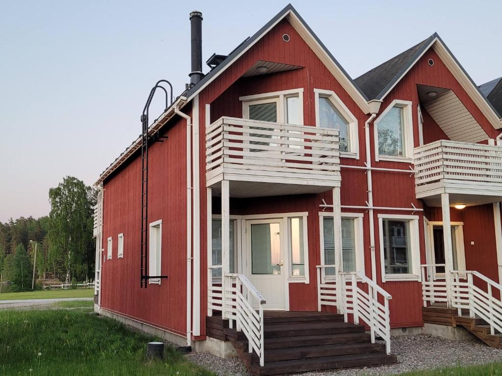 拉彭兰塔Saimaa Marina Garden Apartments的一间红色的房子,旁边设有白色的楼梯