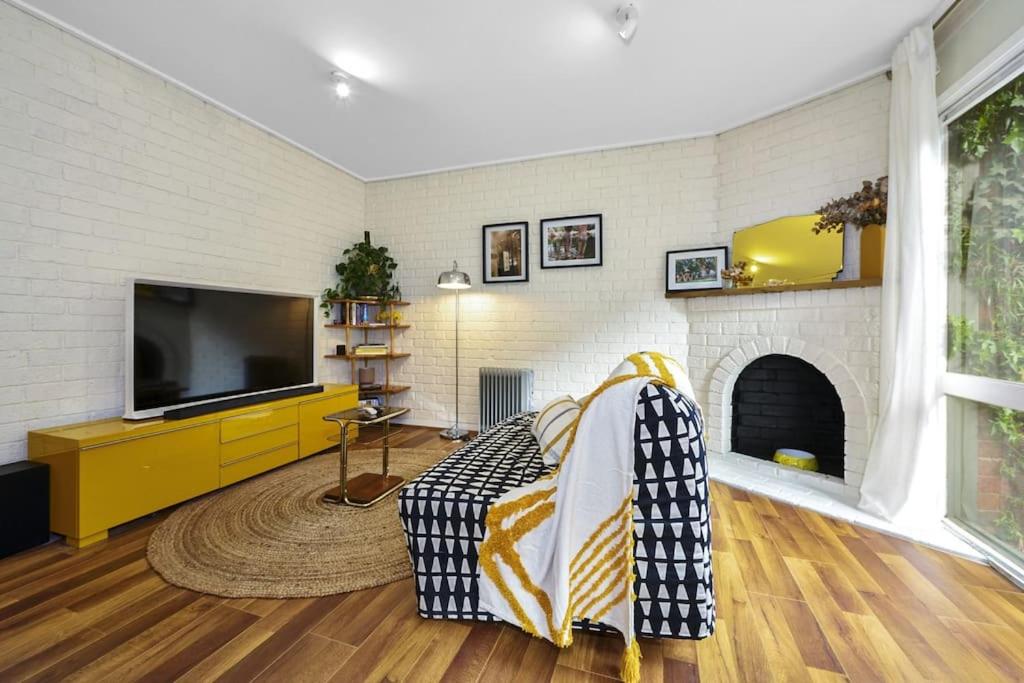 墨尔本Carlton Dream: Leafy 2bed 2bath Lygon Str Townhouse的带沙发和电视的客厅