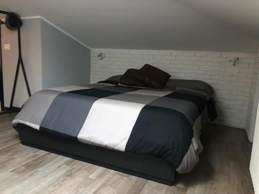 罗马Gioconda’s Apartment的卧室内的一张大床,卧室设有砖墙