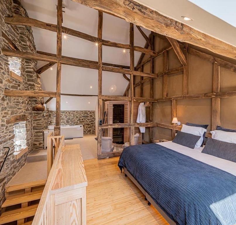斯图蒙Paddock Lodge - Suites Wellness & Chambres d'hôtes的一间卧室设有一张床和石墙