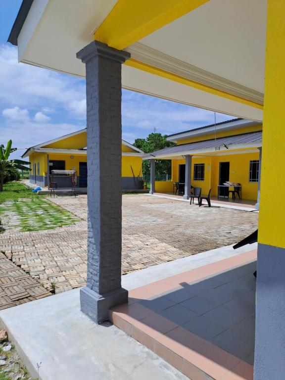 大港Room/Homestay NazaDja的黄色学校建筑,设有大庭院