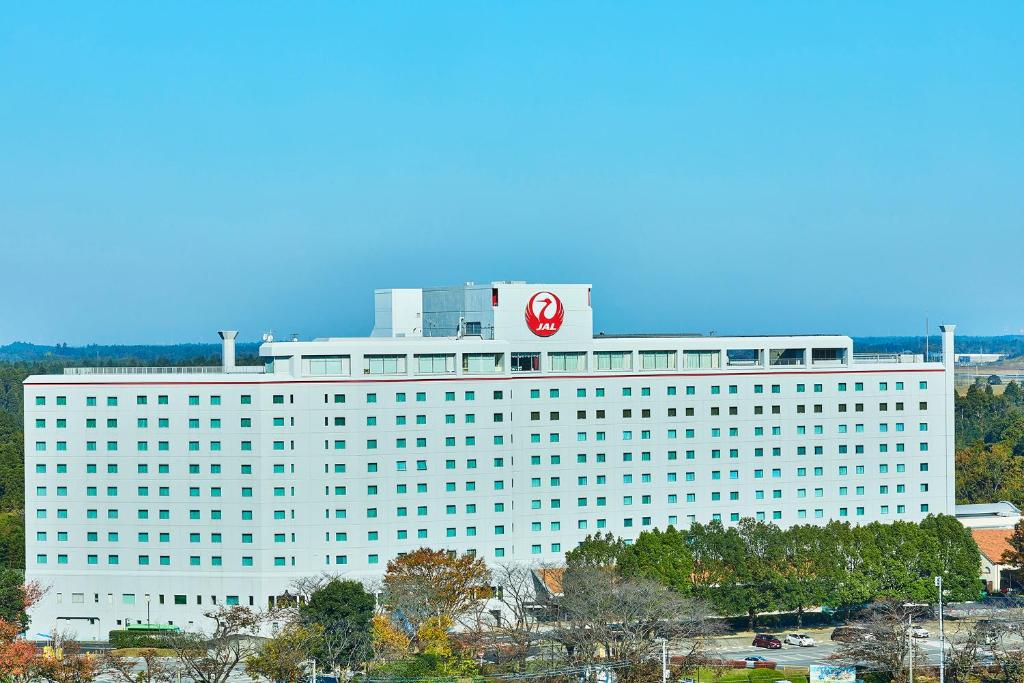 成田日航国际酒店的一座白色的大建筑,上面有红色的标志
