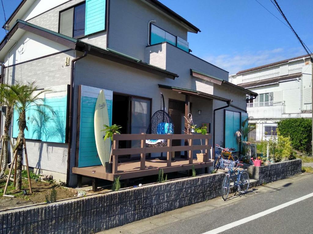 千仓町シーカレント　ゆな　CHIKURA的一个带冲浪板的门廊的房子