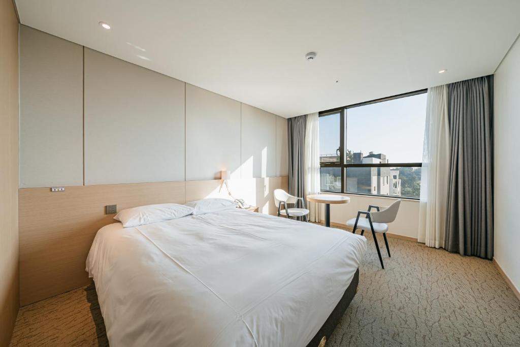 西归浦市Hotel Zinc的酒店客房设有一张大床和一张书桌。