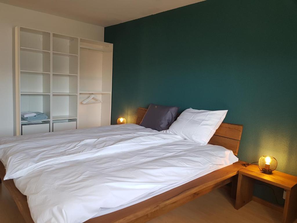 克莱恩 蒙塔纳Appartement Randogne的一间卧室设有一张白色大床和绿色的墙壁