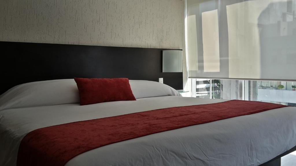 墨西哥城国王套房集团酒店 - 芒特钦博拉索街537号的一间卧室配有一张带红色枕头的大床