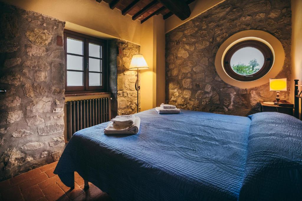 莫拉扎纳Casa Vacanza La Pozza的一间卧室设有蓝色的床和圆形窗户。