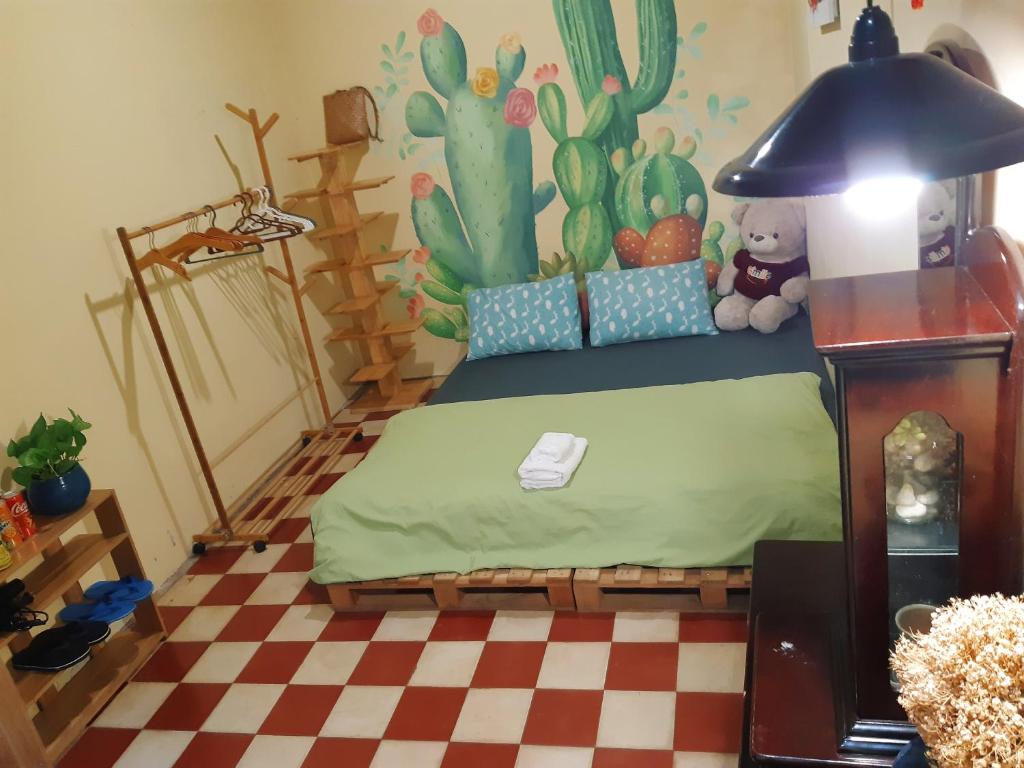 头顿Homestay Gác Mơ Vũng Tàu的一间卧室配有一张带仙人掌墙的床
