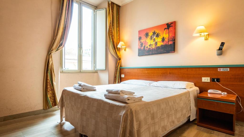罗马中心3号酒店的一间卧室配有带毛巾的床