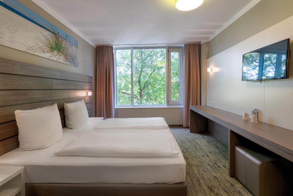 慕尼黑慕尼黑展览郁金香酒店的酒店客房设有两张床和窗户。