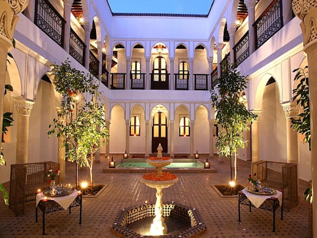 马拉喀什阿卜杜花园庭院酒店的一座建筑中间带喷泉的庭院