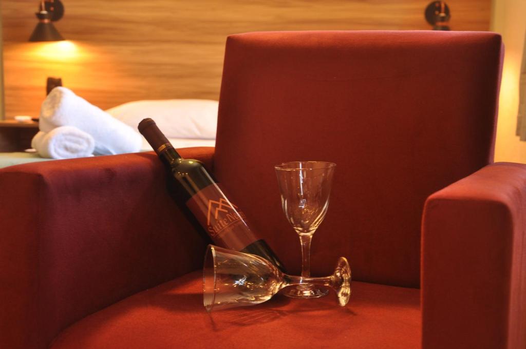 卡内拉Suite Negri的一瓶葡萄酒和一张沙发上的玻璃杯