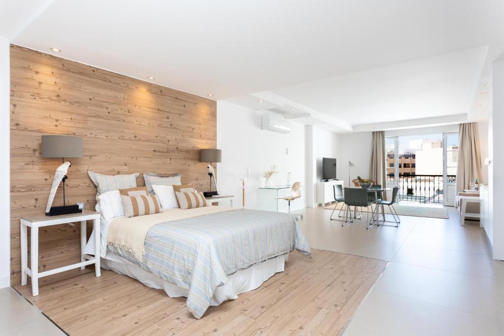 阿雷西费Rooms & Suites Loft 2G Deluxe Edition Arrecife的一间卧室设有一张带木墙的大床