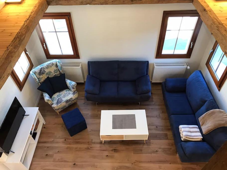 SalgeschLa Maisonnette : charmante maison indépendante的客厅配有蓝色的沙发和桌子