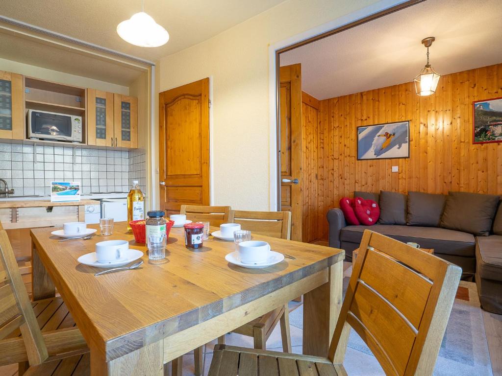 里蒙纽耶Apartment Les Mélèzes-5 by Interhome的厨房以及带木桌和椅子的客厅。