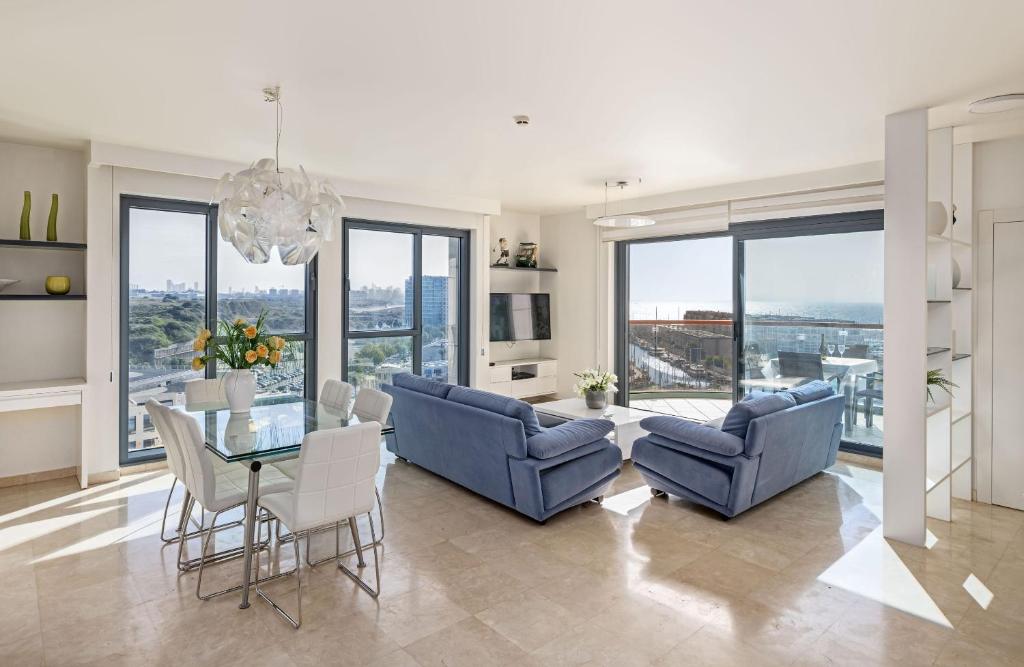 荷兹利亚BMarina view 2bd Luxury Ap的用餐室以及带桌椅的起居室。