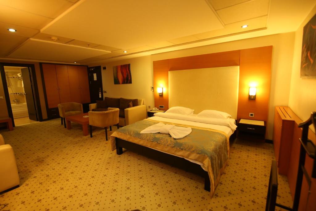 伊斯坦布尔ZEO HOTEL merter的酒店客房带一张床、一张桌子和椅子