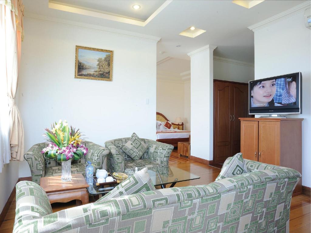 顺安黄燕酒店的客厅配有两张沙发和一台电视机