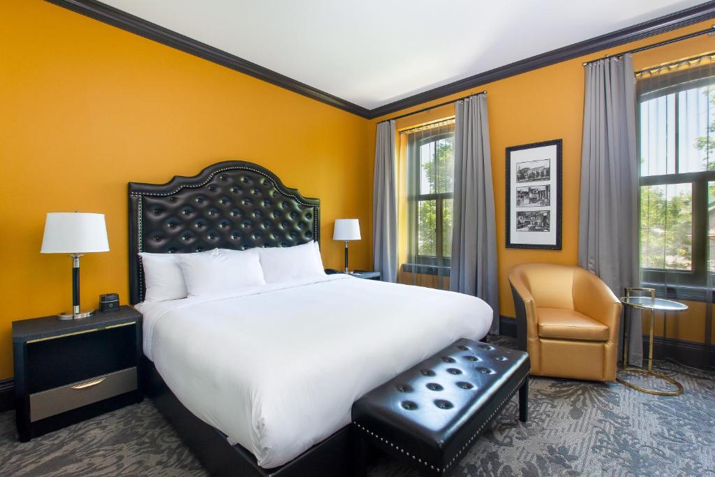 魁北克市克拉伦登酒店的卧室配有一张白色大床和一把椅子
