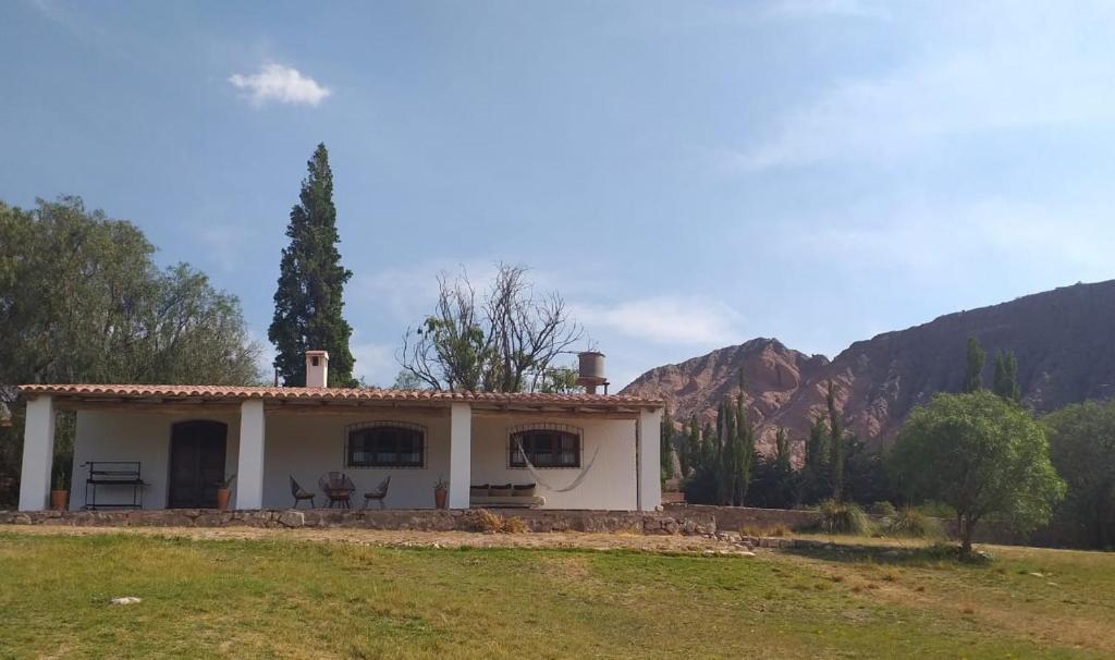 蒂尔卡拉Casona Inkill Huasi II的一座白色的小房子,后面是群山