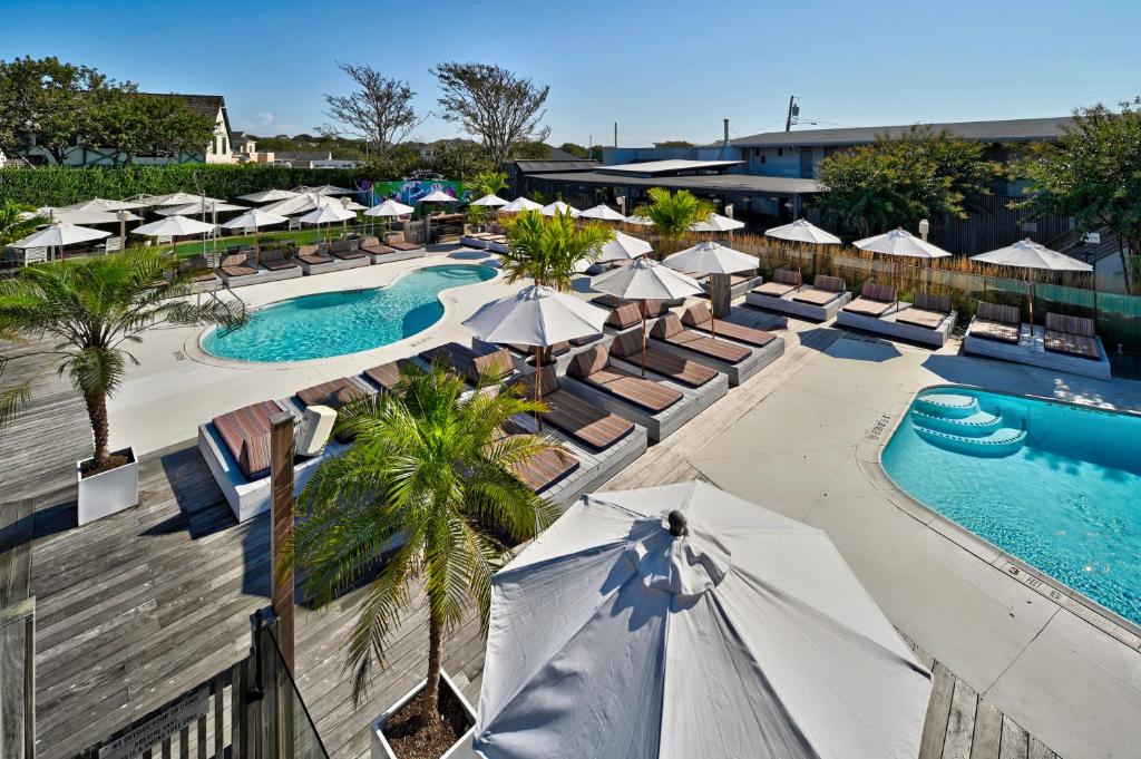 蒙托克蒙托克海滨别墅酒店的享有带遮阳伞和椅子的度假村游泳池的顶部景致