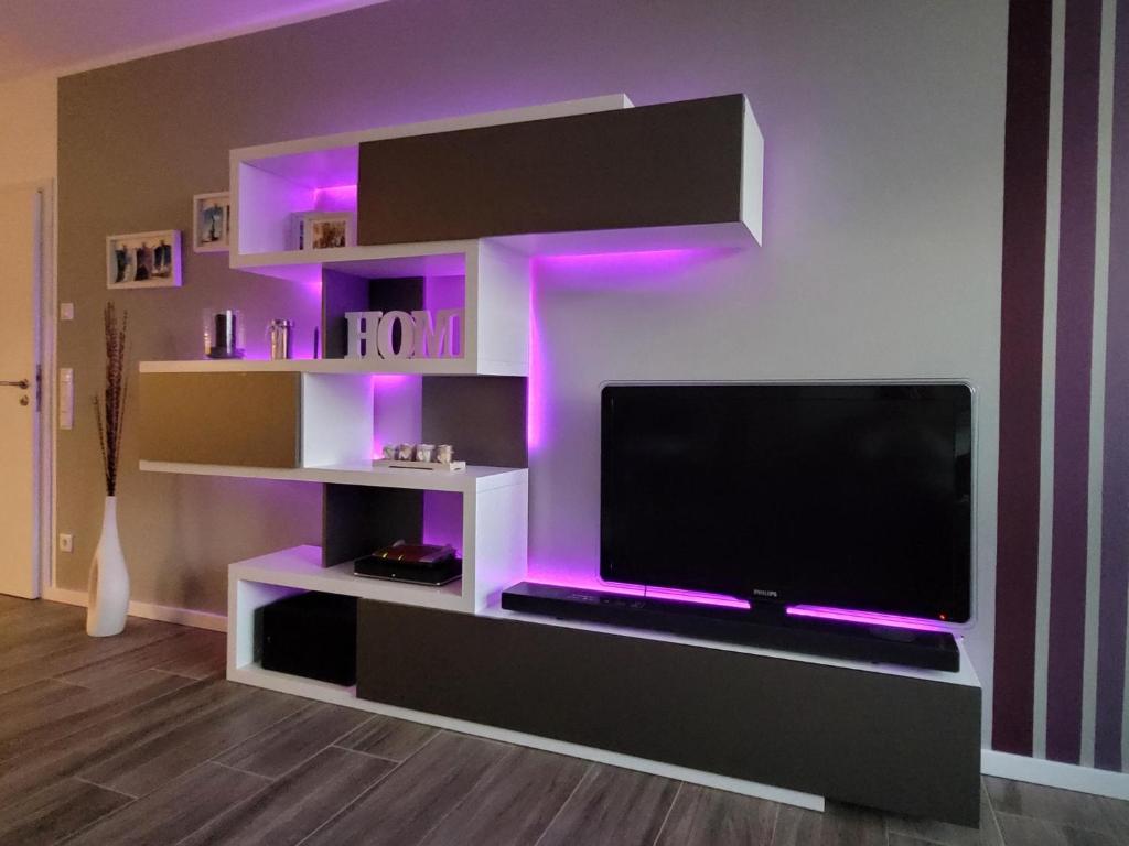 马克莱贝格Leipziger Neuseenland Apartment的客厅配有带紫色灯的电视