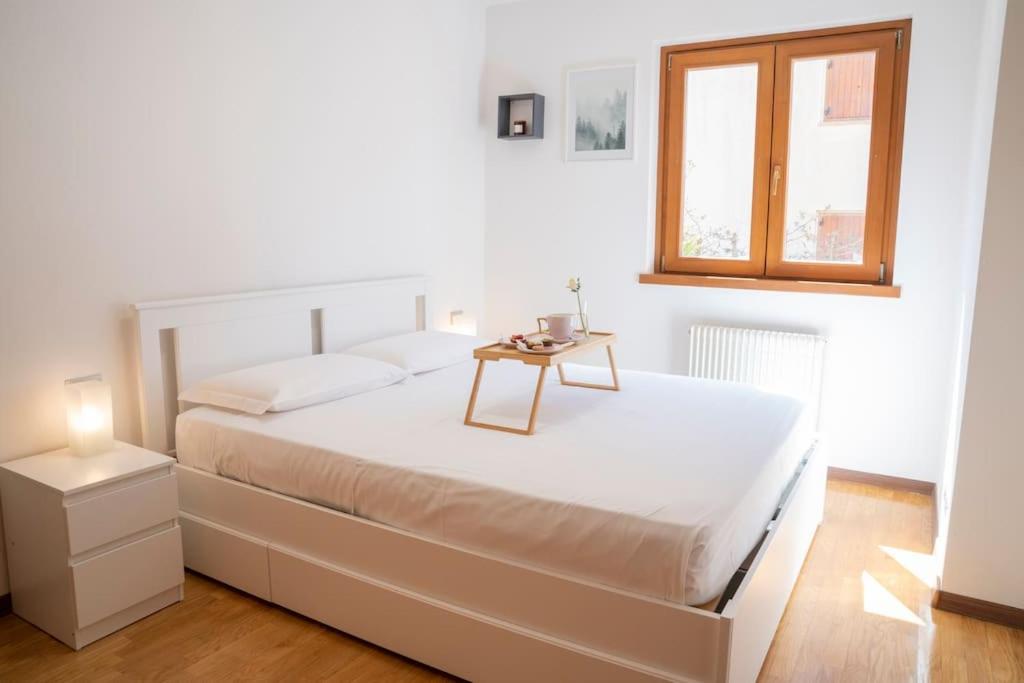 卡韦达戈Nature La Casa della Montagna的白色卧室配有一张桌子和一张床铺