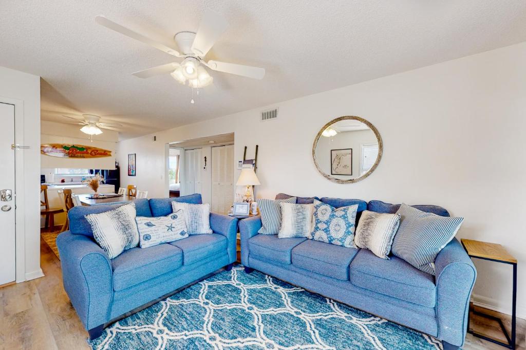 彭萨科拉海滩Villas on the Gulf H10的客厅配有2张蓝色沙发和吊扇