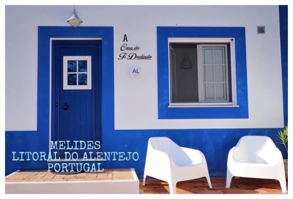 梅利迪什A Casa da Ti Deolinda的两把白色椅子,在蓝色墙壁前,有一扇门