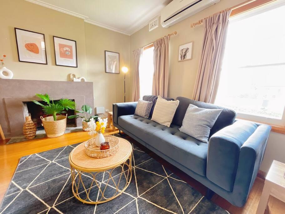 格莱诺基Stunning Hobart 3-bed home- close to shopping centers的客厅配有蓝色的沙发和桌子