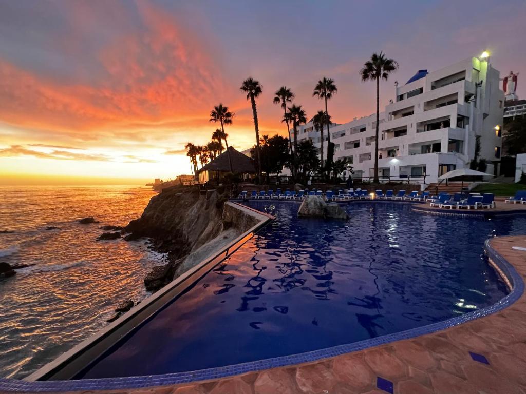 罗萨里托岩石区度假酒店及Spa的海滩上的游泳池,背景是日落
