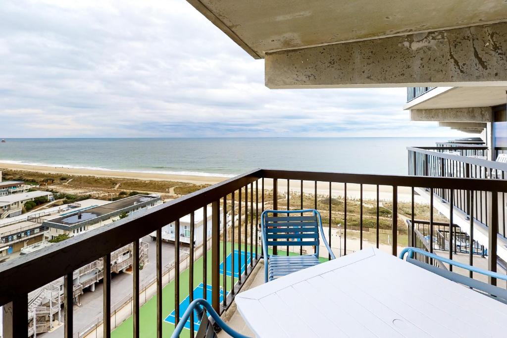 大洋城Sea Watch 1110的一个带桌椅和海滩的阳台