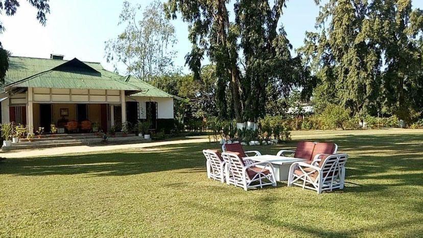 BokākhātNahorjan Tea Homestay的坐在房子前面草坪上的桌椅