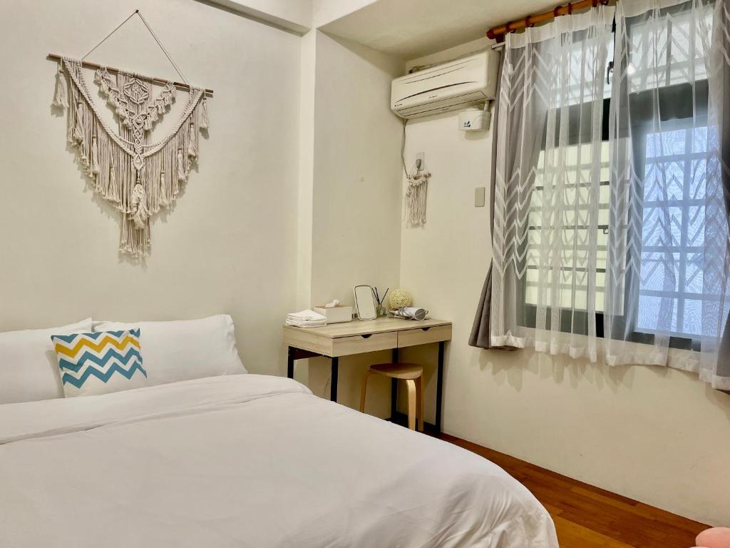 花莲市水上雅居民宿的一间卧室配有一张床、一张书桌和一个窗户。