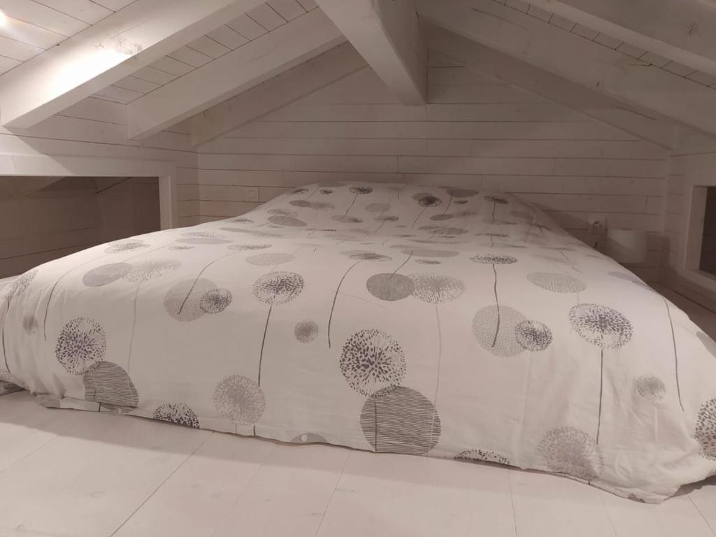 塔卢瓦尔Maisonnette的一张带白色床单的床,上面有蒲公英