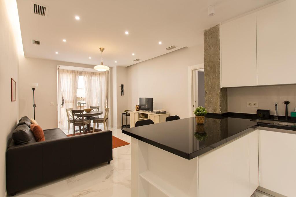 格拉纳达Apartamento San Isidro Centro的厨房以及带黑色台面的起居室。