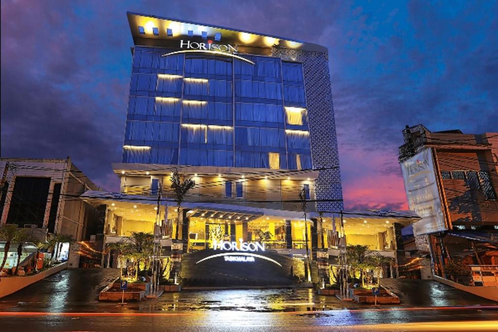 打横Horison Tasikmalaya的夜间标有标志的酒店大楼