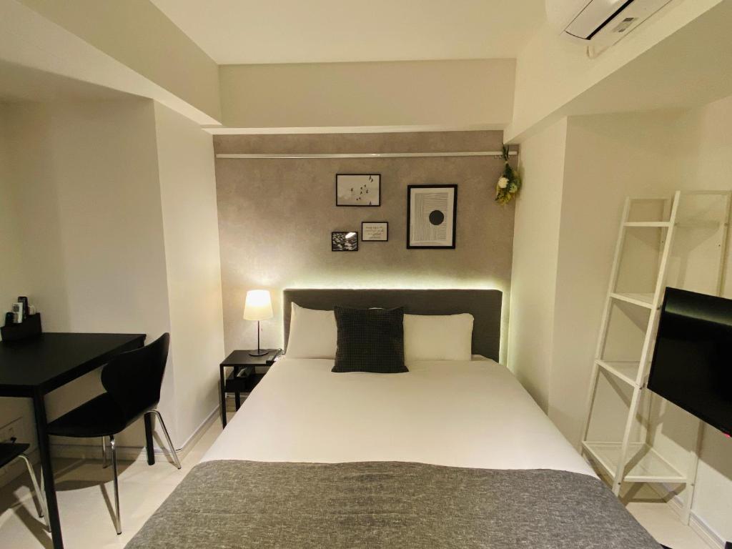 东京FLOWER TERRACE Higashi Shinjuku的一间卧室配有一张床、一张桌子和一张四柱床。