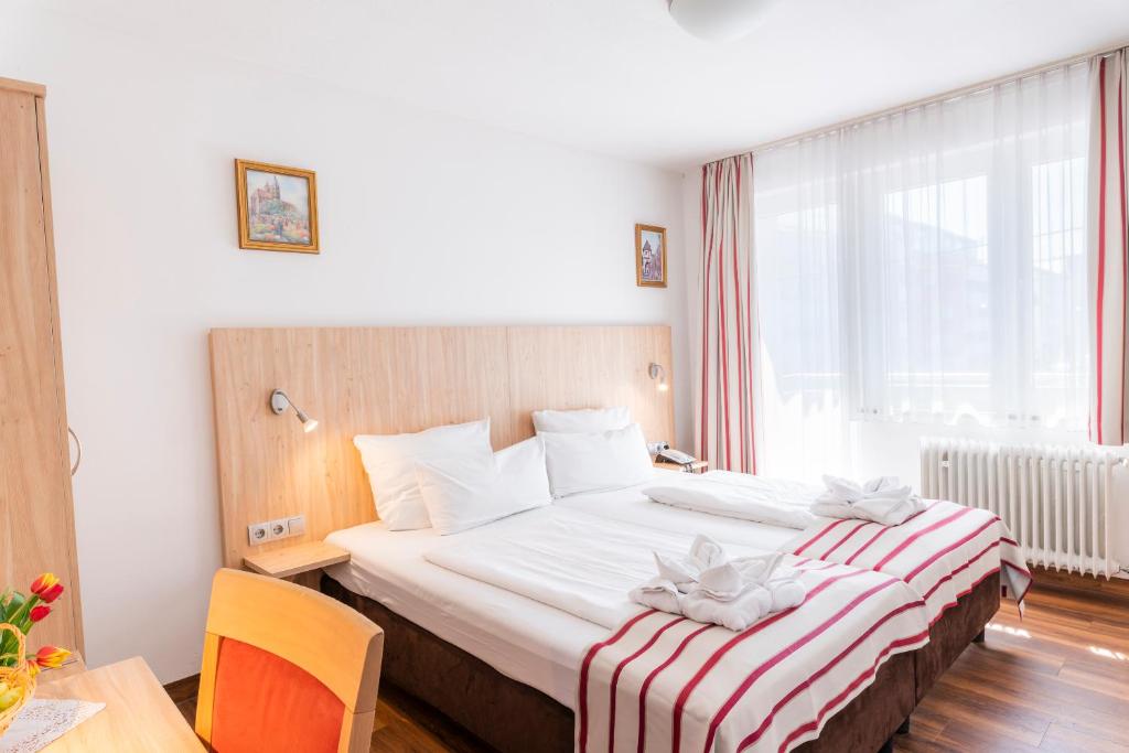 斯图加特Hotel Astoria Stuttgart City的酒店客房,配有带条纹毯子的床