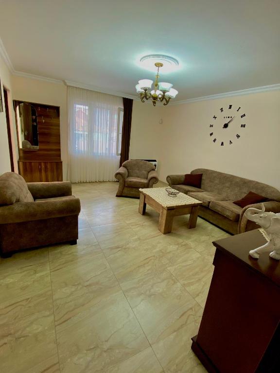 巴统Family Home的客厅配有沙发和墙上的时钟