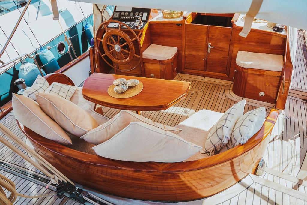博德鲁姆The Opportunity to Live on a sailing yacht in Bodrum Marina的船上的木船,配有桌椅