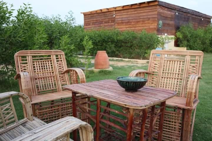 Tunisمنتجع تونس فاير- Tunis Fire Resort的一张木桌,上面有两把椅子和碗