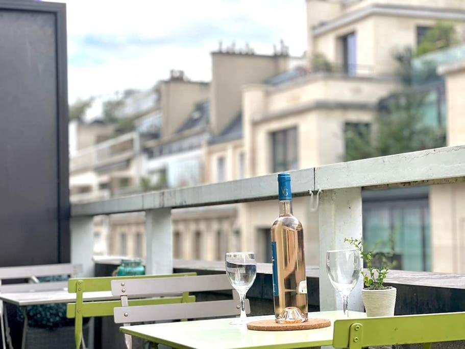 巴黎Champs Élysées-Belle terrasse, luxueux appartement的一张桌子上放着一瓶葡萄酒,放上两杯