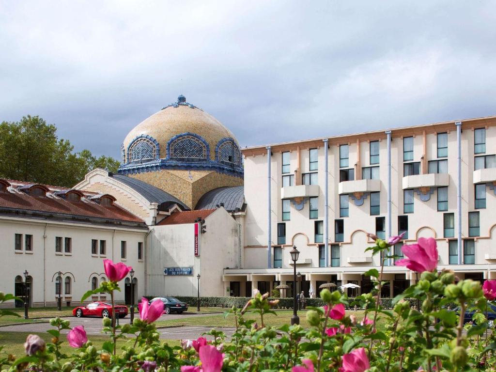维希维希特玛利亚美居酒店的一座建筑,有一座清真寺,有粉红色的花朵