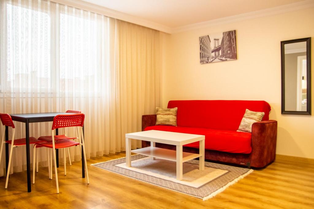 伊兹密尔Colorful and Central Flat near Kulturpark Izmir的客厅配有红色的沙发和桌子