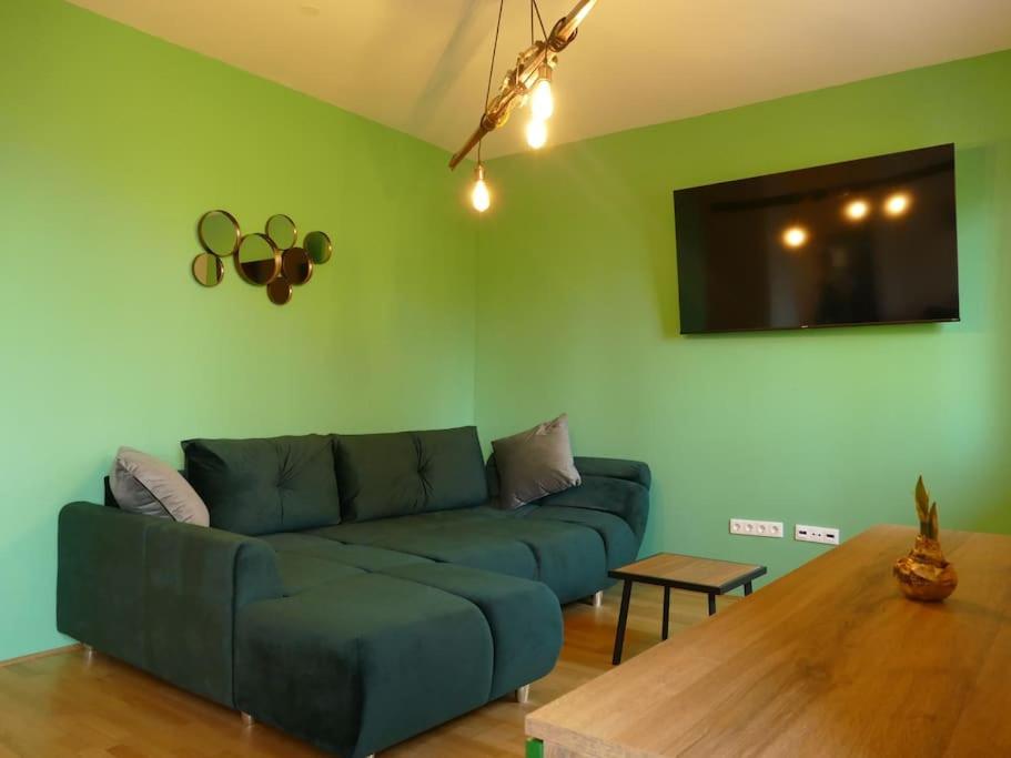 霍茨科波霍尔耶Forest Green Pohorje Apartment的客厅配有蓝色的沙发和桌子