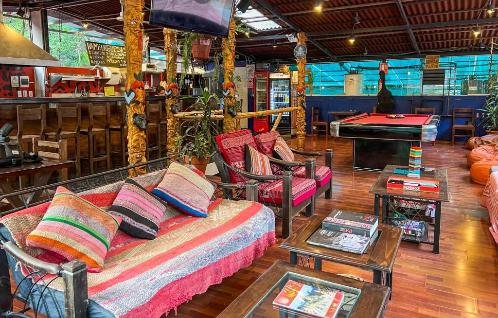 马丘比丘Nativus Hostel Machu Picchu的客厅配有沙发、椅子和桌子