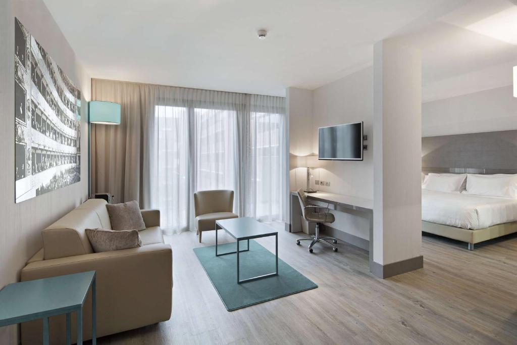 帕尔马帕尔马NH酒店的酒店客房设有床和客厅。