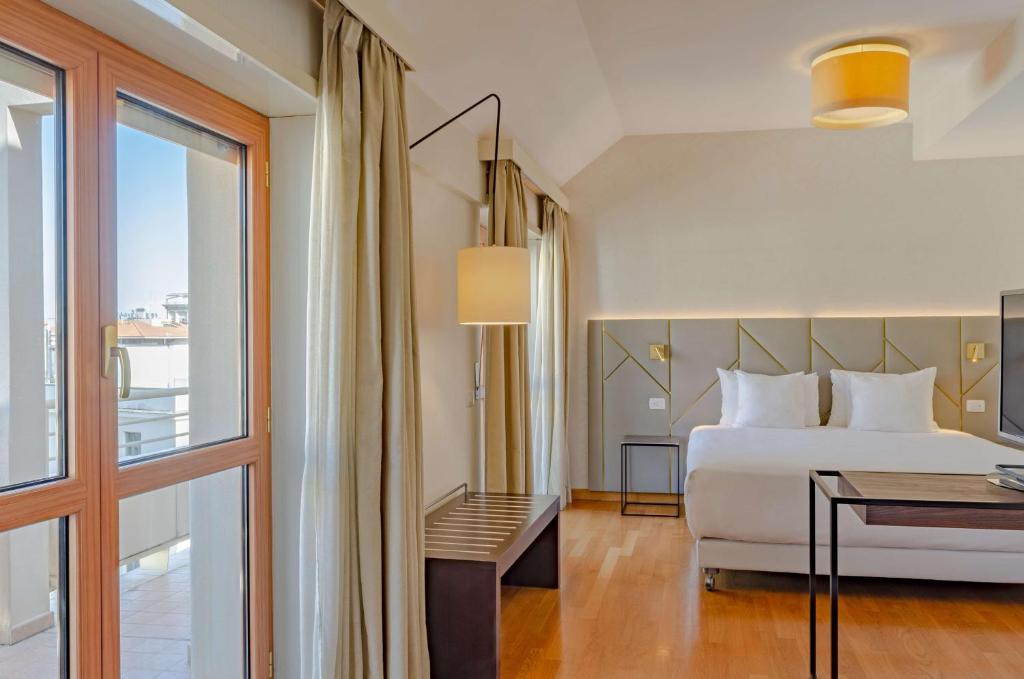 罗马罗马查士丁尼NH系列酒店的酒店客房设有床和窗户。