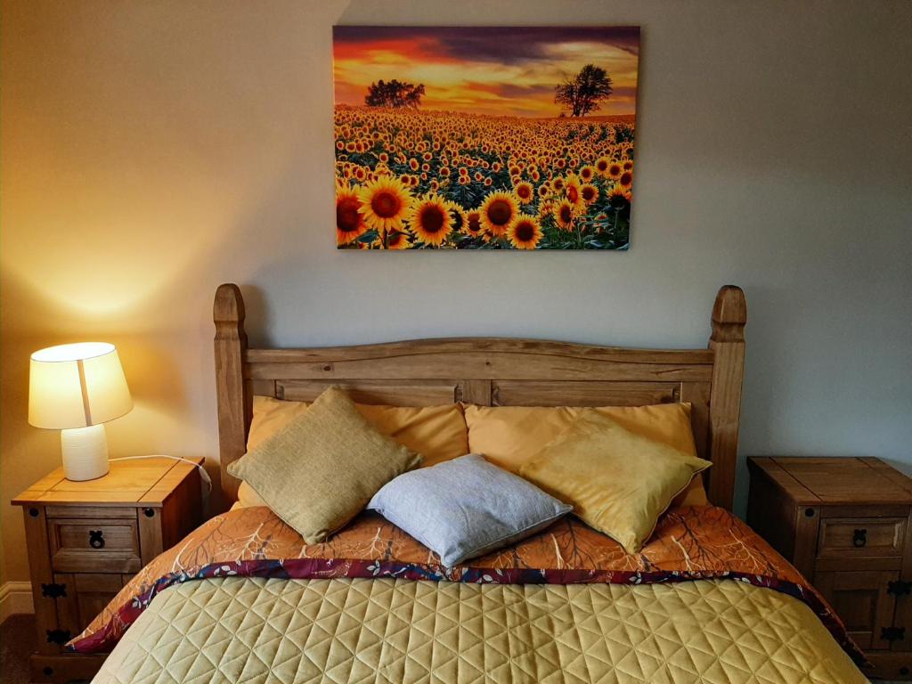 奥勒顿Maria`s Garden House的一间卧室配有一张床,画着向日葵